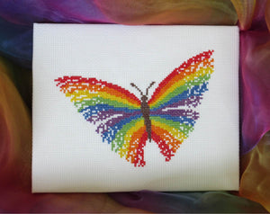 Cross stitch picture of a butterfly with rainbow coloured wings