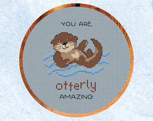 Otterly Amazing cross stitch pattern. Cartoon of an otter with the words "You are otterly amazing". Shown in six inch hoop.
