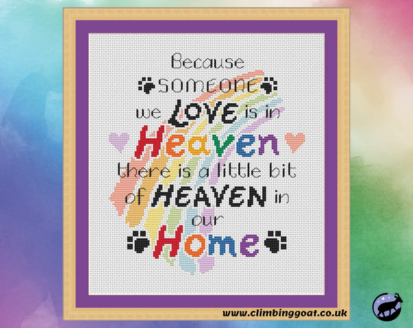 Pet memorial cross stitch pattern with the words "Because someone we love is in heaven, there is a little bit of heaven in our home" arranged over a pastel rainbow. Shown in frame.