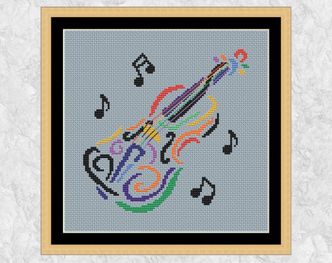 Rainbow Violin cross stitch pattern. Silhouette of a violin in rainbow colours, with black musical notes around it. Shown in frame.