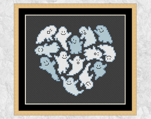 Ghostly Heart Halloween cross stitch pattern. Heart shape made out of fun ghosts. Shown with frame.