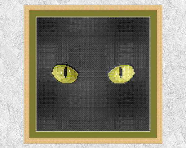 Cat's Eyes cross stitch pattern. Shown in frame.