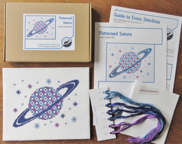 Patterned Saturn cross stitch kit - kit contents: labelled box, guide to cross stitching, cross stitch pattern, pre-sorted DMC threads, fabric and needle.