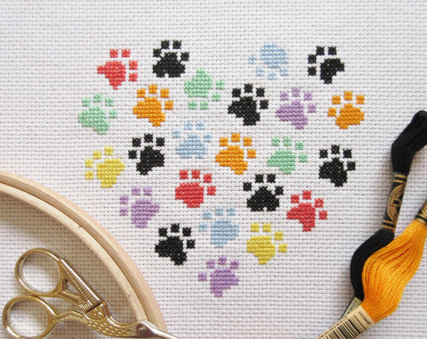 Stitched image of smaller paw print heart cross stitch pattern, in rainbow colours