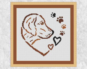 Cross stitch pattern PDF of a dog, hearts and paw prints forming a larger heart. Shown with frame.