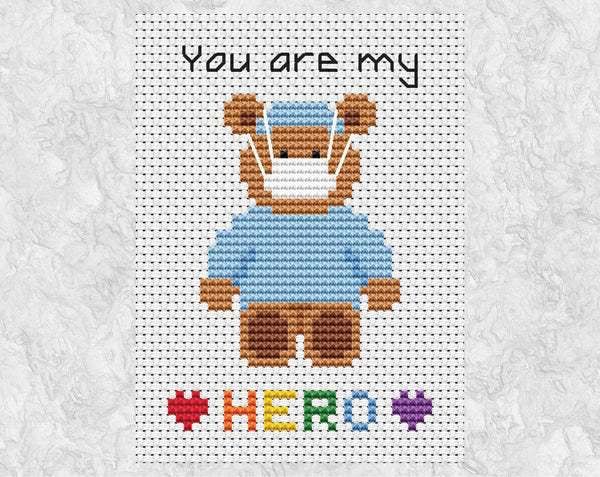 Cross stitch pattern of teddy bear wearing scrubs and face masks, with the words 'You are my HERO'. Shown without frame.