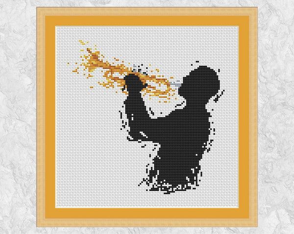 Modern art cross stitch pattern of a male trumpet player. Shown with frame.