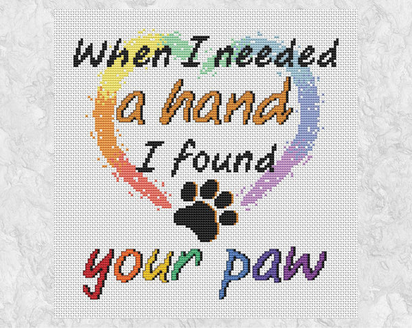 Cross stitch pattern PDF of the words "When I needed a hand I found your paw", with a heart and paw print. Shown without frame.