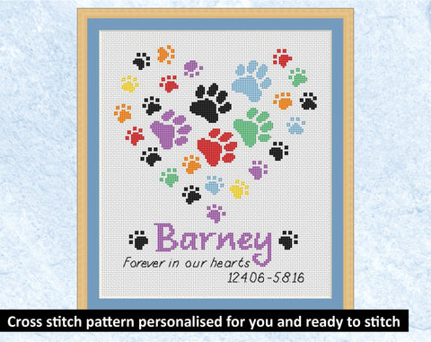 Custom cross stitch pattern of a rainbow coloured paw print heart with the name of your pet below it, the words "Forever in our hearts" and the dates of the pet's life if the pet has passed away (or without dates if preferred). Example piece with the name 'Barney'.