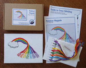 Complete cross stitch kit of a rainbow design - photo shows the completed pattern, box, instructions, fabric, needle and threads