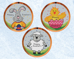 Three mini cross stitch patterns in hoops, showing an Easter bunny, chick and lamb