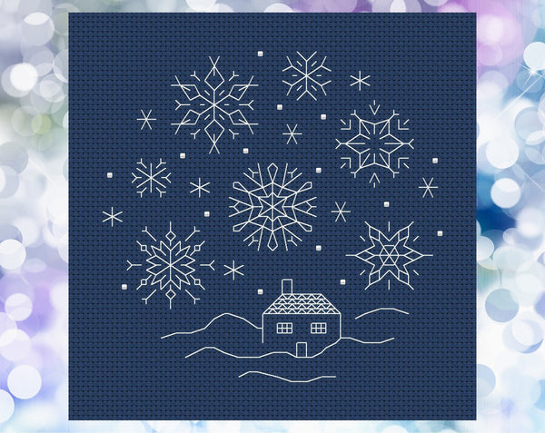 Blackwork Snow Scene cross stitch pattern. Six sided backstitched snowflakes falling on a small cottage. Shown without frame.