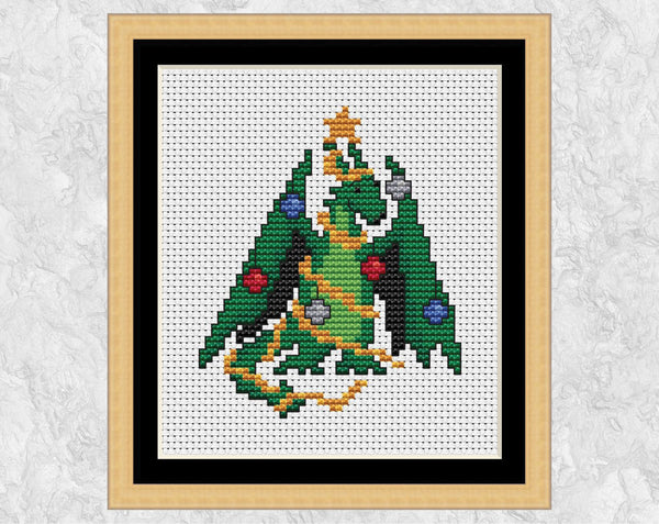 Christmas Tree Dragon cross stitch pattern. A small picture of a dragon dressed up as a Christmas Tree. Shown in frame.