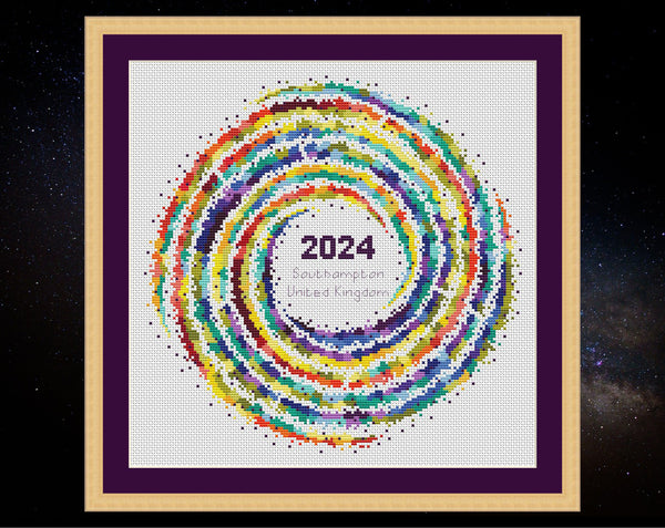 Rainbow Temperature Galaxy cross stitch pattern - example image for Southampton for 2024, shown on white fabric in square frame. Maximum and minimum temperatures pattern version.