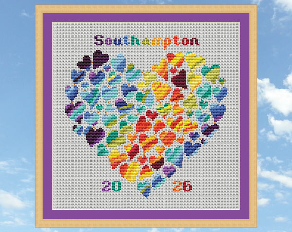 Rainbow Temperature Heart cross stitch pattern. Shown in frame on white fabric.