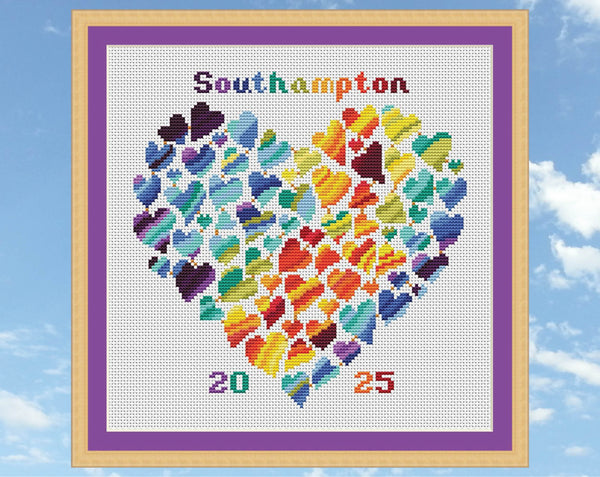 Rainbow Temperature Heart cross stitch pattern. Shown in frame on white fabric.