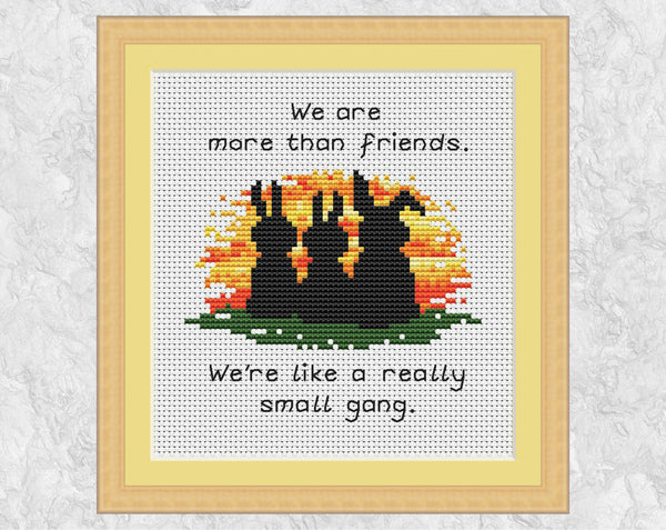 Really Small Gang Friendship cross stitch pattern. Three bunnies watching a sunset with the words 'We are more than friends. We're like a really small gang.' Shown in frame.