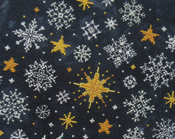 Snowflakes and Stars cross stitch pattern. Close up of stitching in piece.