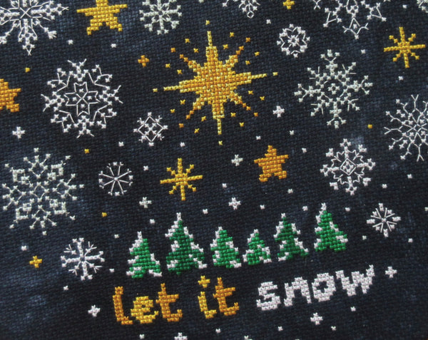Snowflakes and Stars cross stitch pattern. Close up of stitching in piece.