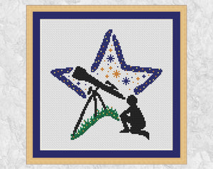 Stargazing Star cross stitch pattern. Silhouette of a person gazing through a telescope with a star shaped background. Shown in frame.