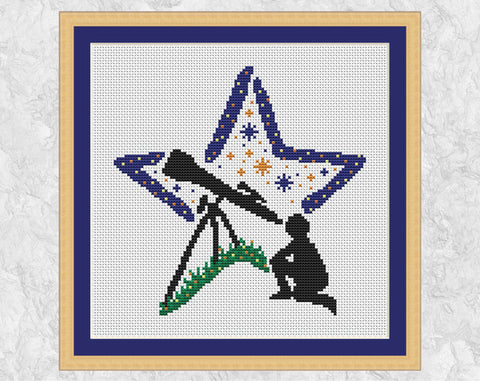 Stargazing Star cross stitch pattern. Silhouette of a person gazing through a telescope with a star shaped background. Shown in frame.