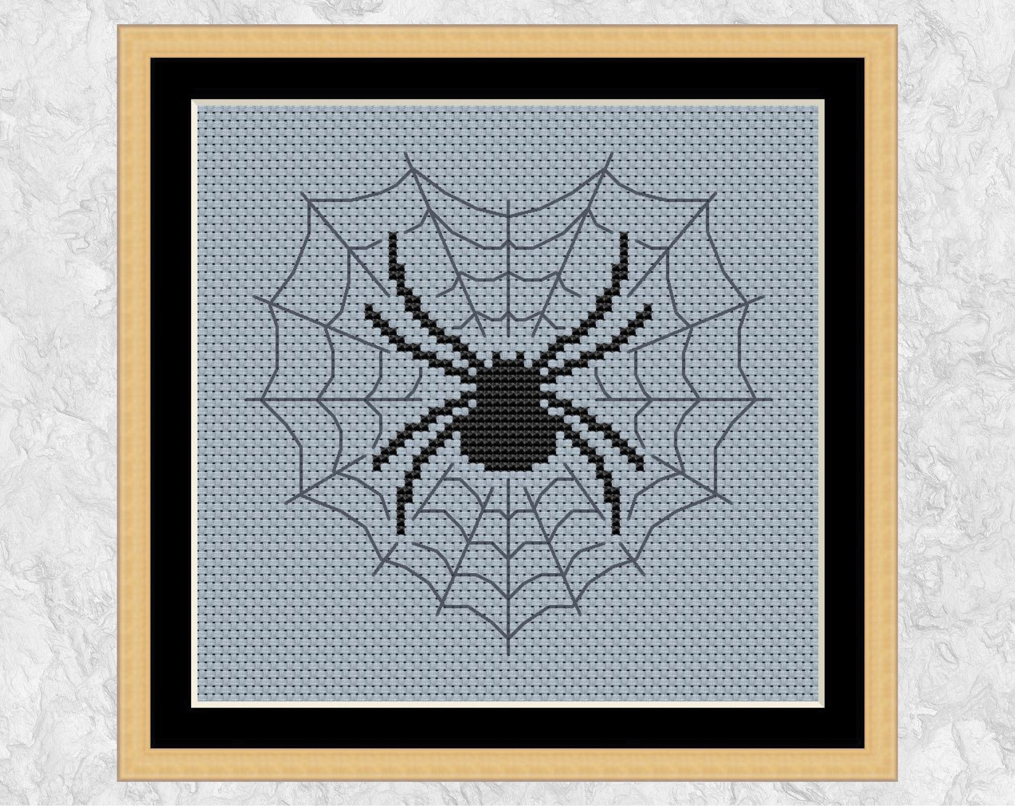 A Spider's Heart cross stitch pattern. A large spider in a heart-shaped web. Shown with frame.