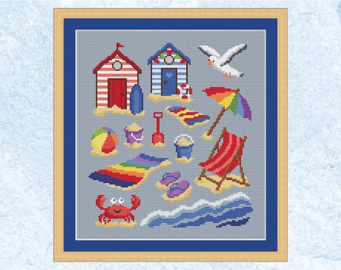 Beach Days cross stitch pattern - fun colourful design featuring beach huts, seagull, parasol, beach towels, spades, buckets, beach ball, deckchair, flipflops, crab, sand and waves. Shown with frame.