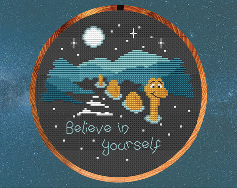 'Believe in Yourself' cross stitch pattern. Nessie the Loch Ness monster in the dark loch with the words 'Believe in yourself'. Shown in hoop.