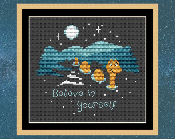 'Believe in Yourself' cross stitch pattern. Nessie the Loch Ness monster in the dark loch with the words 'Believe in yourself'. Shown in frame.