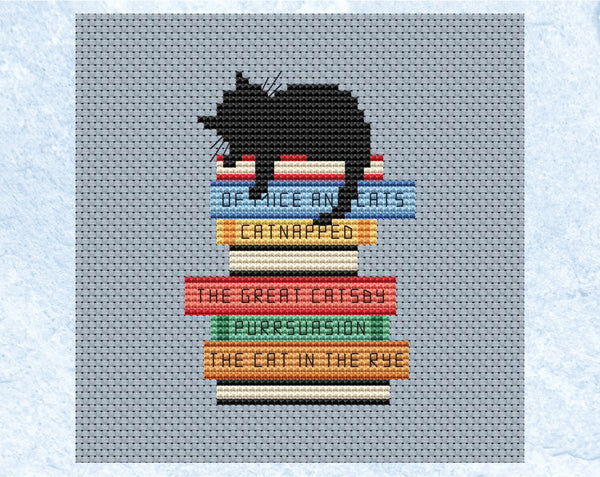 Catnapped cross stitch pattern. Black cat asleep on a pile of books with pun titles. Shown without frame.