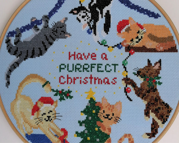 Christmas Cats cross stitch pattern. Six fun cartoon cats putting up Christmas decorations. Close up of pattern.