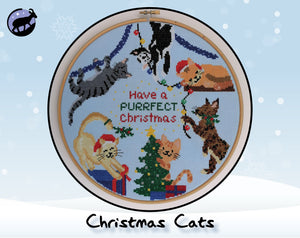 Christmas Cats cross stitch pattern. Six fun cartoon cats putting up Christmas decorations. Shown in hoop.
