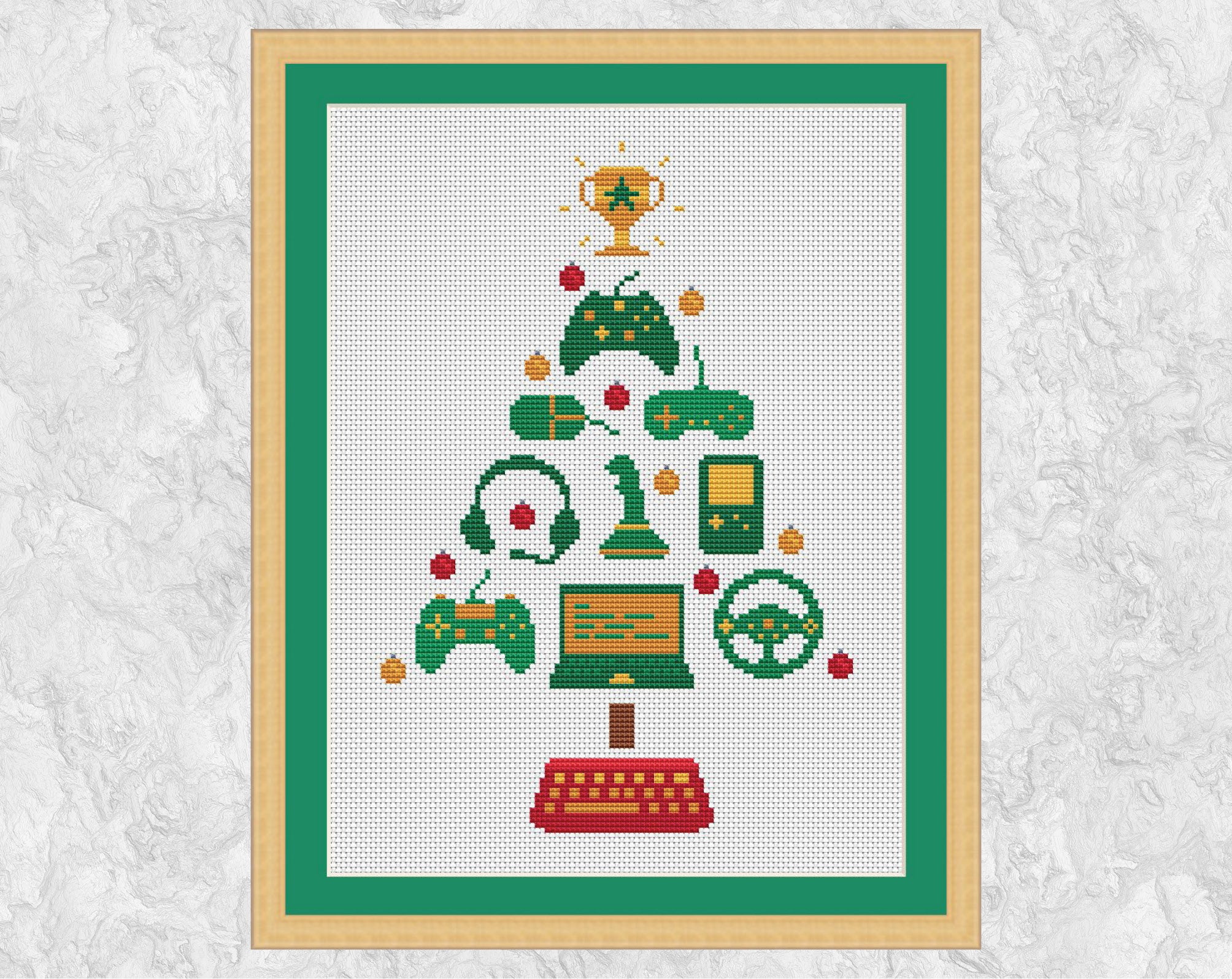 Computer Gamers' Christmas Tree cross stitch pattern. The tree features three consoles, a mouse, a joystick, a handheld game, a game driving wheel, a laptop and baubles, and a keyboard forms the pot. Shown with frame.