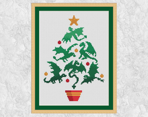 Dragon Christmas Tree cross stitch pattern. Christmas tree shape made up of dragon silhouettes. Shown with frame.