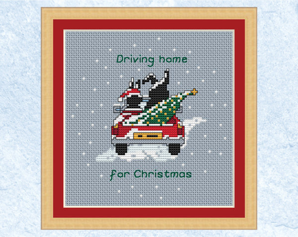 Driving Home for Christmas cross stitch pattern - the two Together Bunnies in a car with a Christmas tree in the back. Shown in frame.