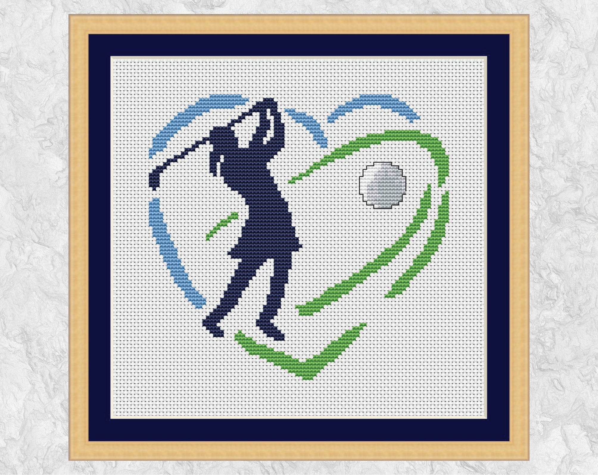 Golf Heart cross stitch pattern, with golfer wearing a skirt. Shown in frame.
