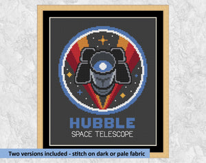 Hubble Space Telescope cross stitch pattern. Shown on black fabric in frame with the text 'Two versions included - stitch on dark or pale fabric'