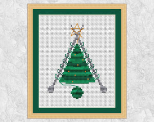 Knitted Christmas Tree cross stitch pattern. A knitted Christmas Tree shape still on the knitting needles, with a ball of yarn forming the pot. Shown with frame.