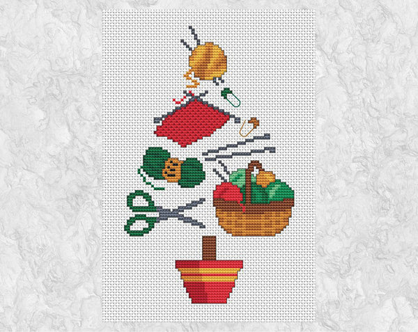 Knitting Christmas Tree cross stitch pattern. A Christmas tree shape made up of yarn, knitting, knitting needles, scissors, a basket of yarn and stitch markers. Shown without frame.