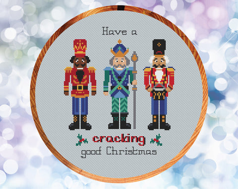 Nutcracker cross stitch pattern. Three Nutcracker soldiers with the words 'Have a cracking good Christmas'. Shown in hoop.