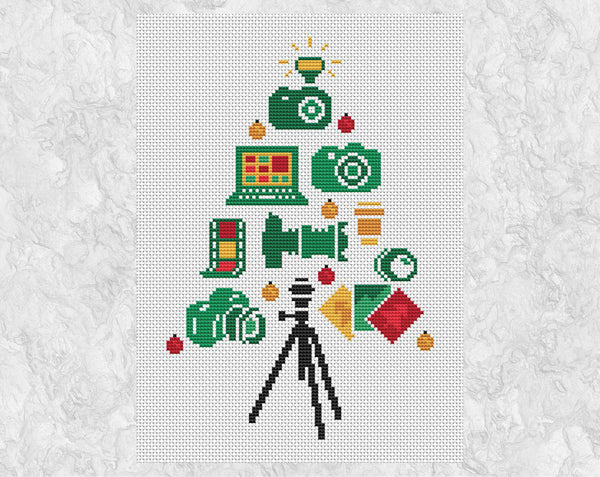 Photographers' Christmas Tree cross stitch pattern: the tree features four cameras, two camera lenses, film negatives, a laptop and photo prints. The flash of one of the cameras forms the Christmas tree star, and a tripod forms the base of the tree. Shown without frame.