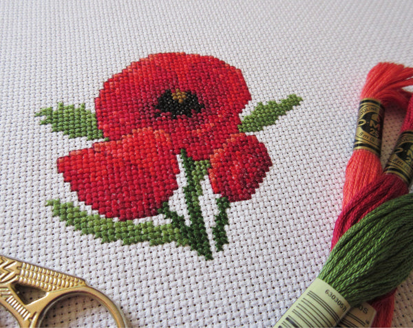 Poppies cross stitch pattern - angled view of stitched piece with props