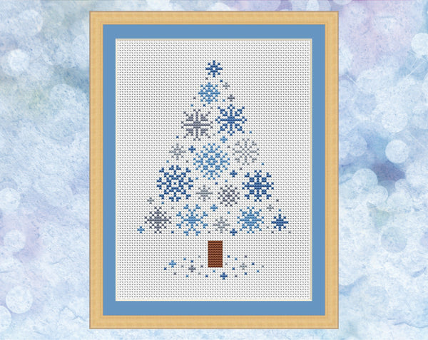 Snowflakes Christmas Tree cross stitch pattern - xmas tree made up of small snowflakes. Version with blue and grey snowflakes on white fabric, shown with frame.