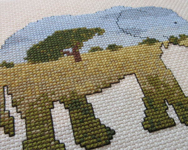 Elephant cross stitch kit - everything you need to stitch a silhouette of an elephant filled with a scene of the African savannah. Angled view of stitched piece.