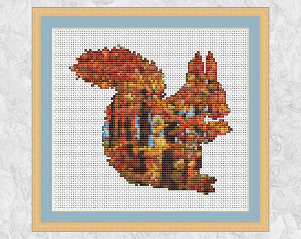 Cross stitch pattern of a squirrel filled with a scene of richly coloured autumn woodland - with frame