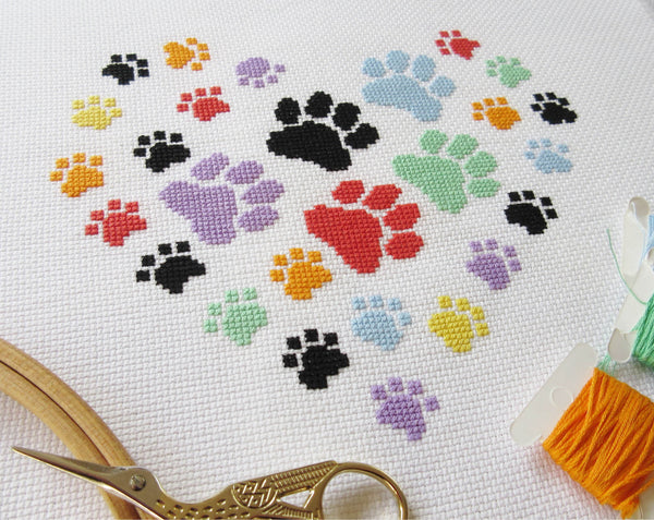 Paw print heart cross stitch pattern - angled picture of rainbow coloured piece