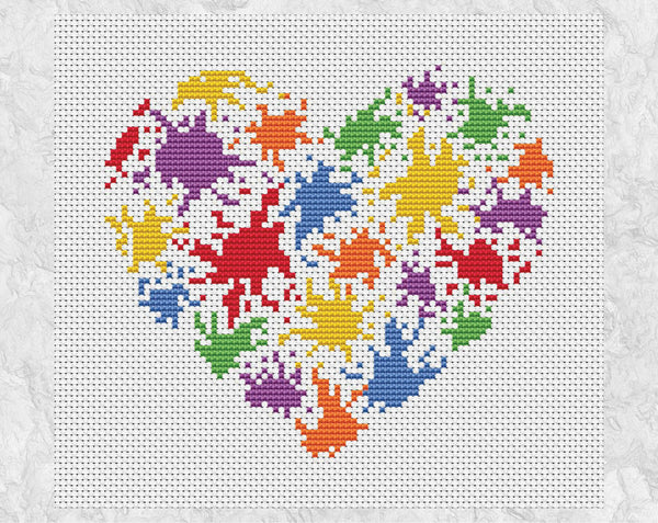 Bright cross stitch pattern of a splattered paint heart in rainbow colours. Shown without frame.