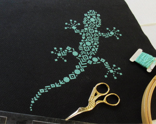 Geometric Gecko cross stitch pattern - stitched piece with props