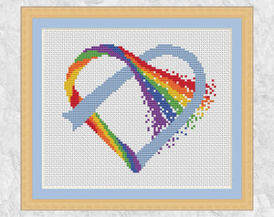 Knotted Rainbow Heart cross stitch pattern on white fabric, with frame