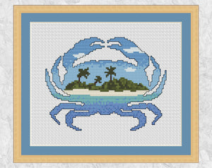 Cross stitch pattern PDF of the silhouette of a crab filled with a beautiful desert island beach. With frame.
